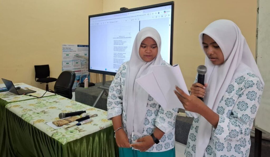 (Gambar 3: Perwakilan siswi mencoba membacakan hikayat Aceh)